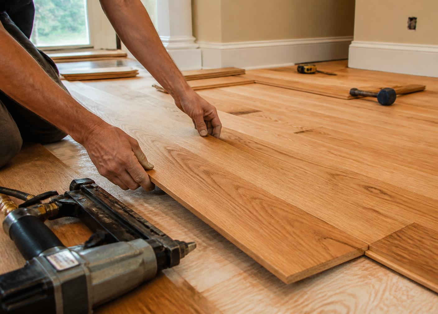 Installer laying new oak hardwood planks in a home